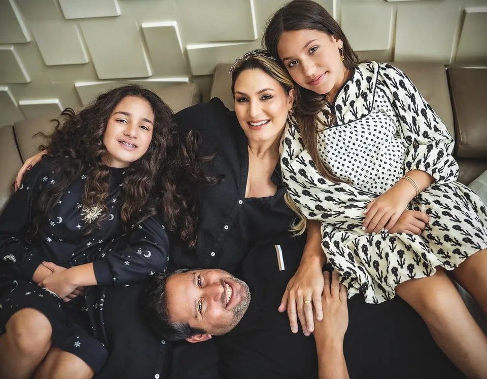 Miriam con su familia, sonriendo, vestidos de blanco y negro
